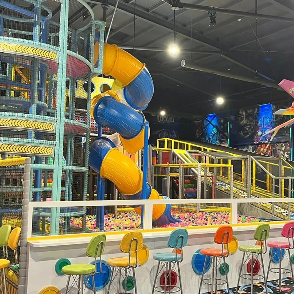 Large indoor play center with spiraling slides and colorful custom structures