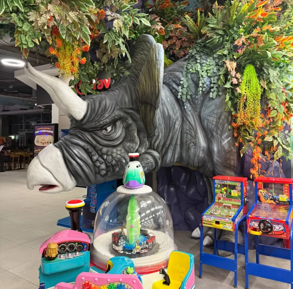 Triceratops sculpture emerging from tropical plants