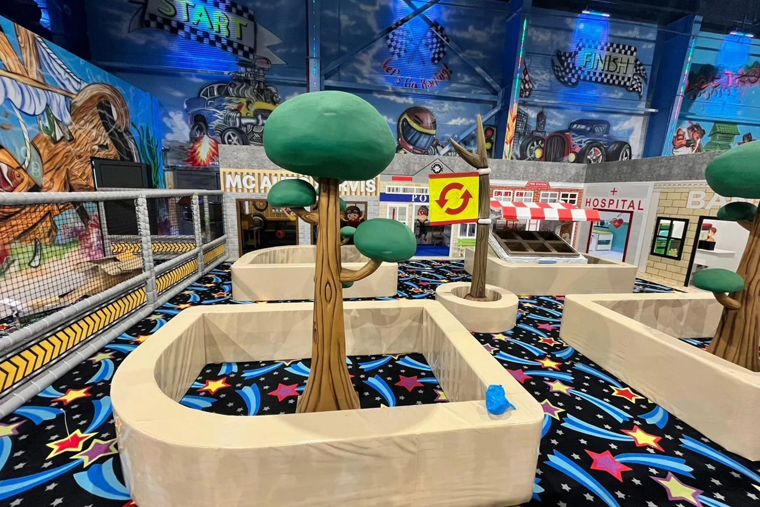 Indoor miniature city with stylized trees, streets and storefronts