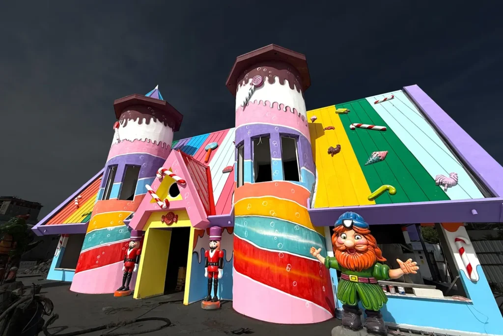 Colorful fairytale castle facade with striped towers and whimsical sculpted characters