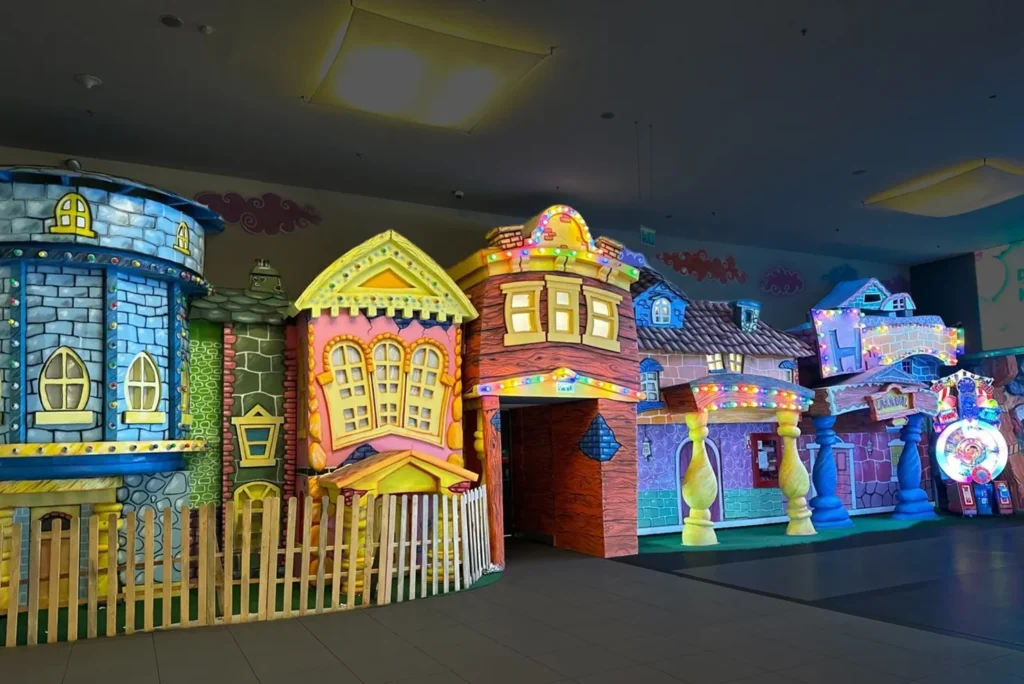 Colorful indoor storybook village with custom decorated playhouse facades
